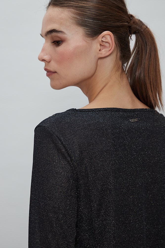 POLERA CON BRILLO Y TACHAS EN LOS HOMBROS